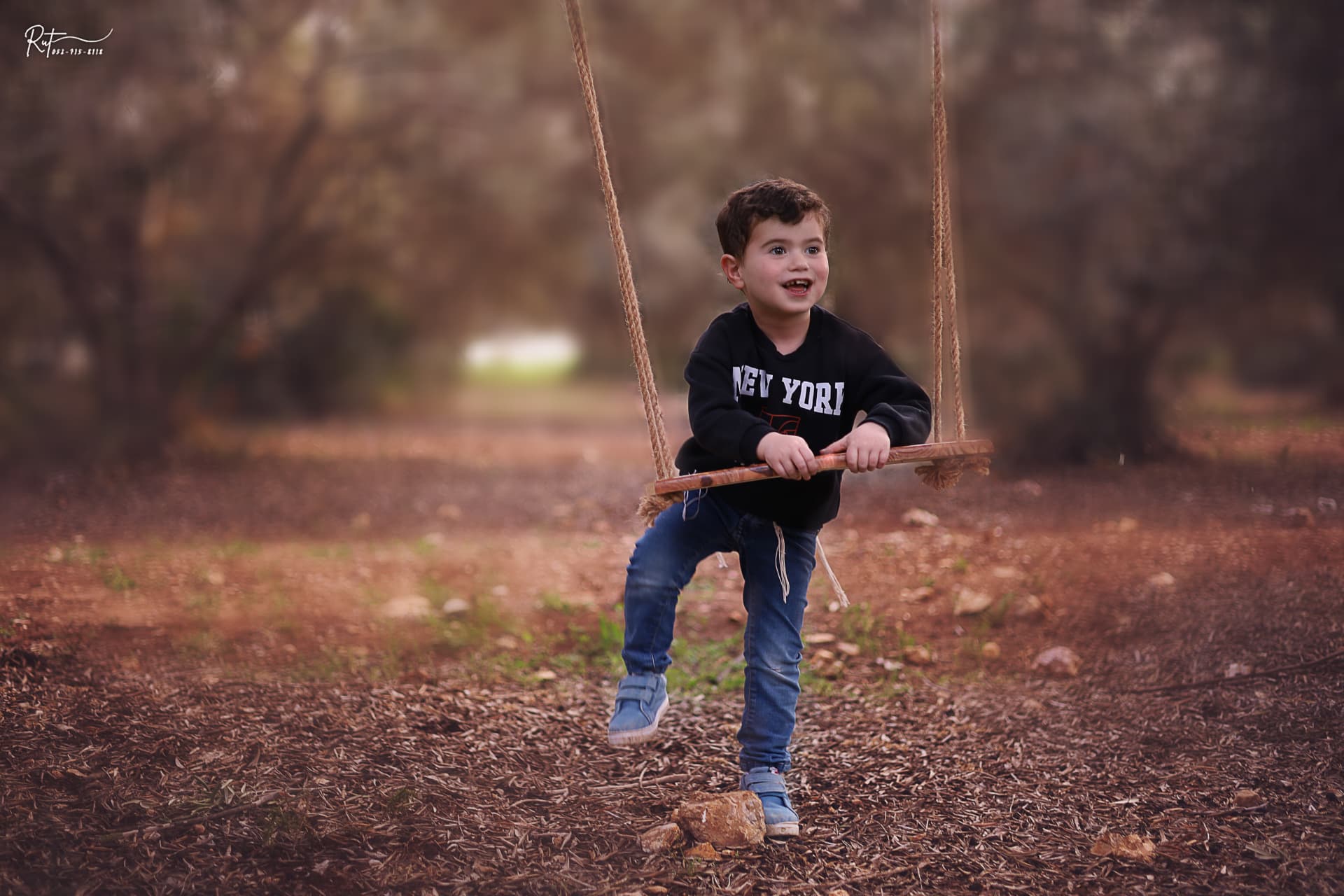 ילד מתנדנד על נדנדת חבלים ביער